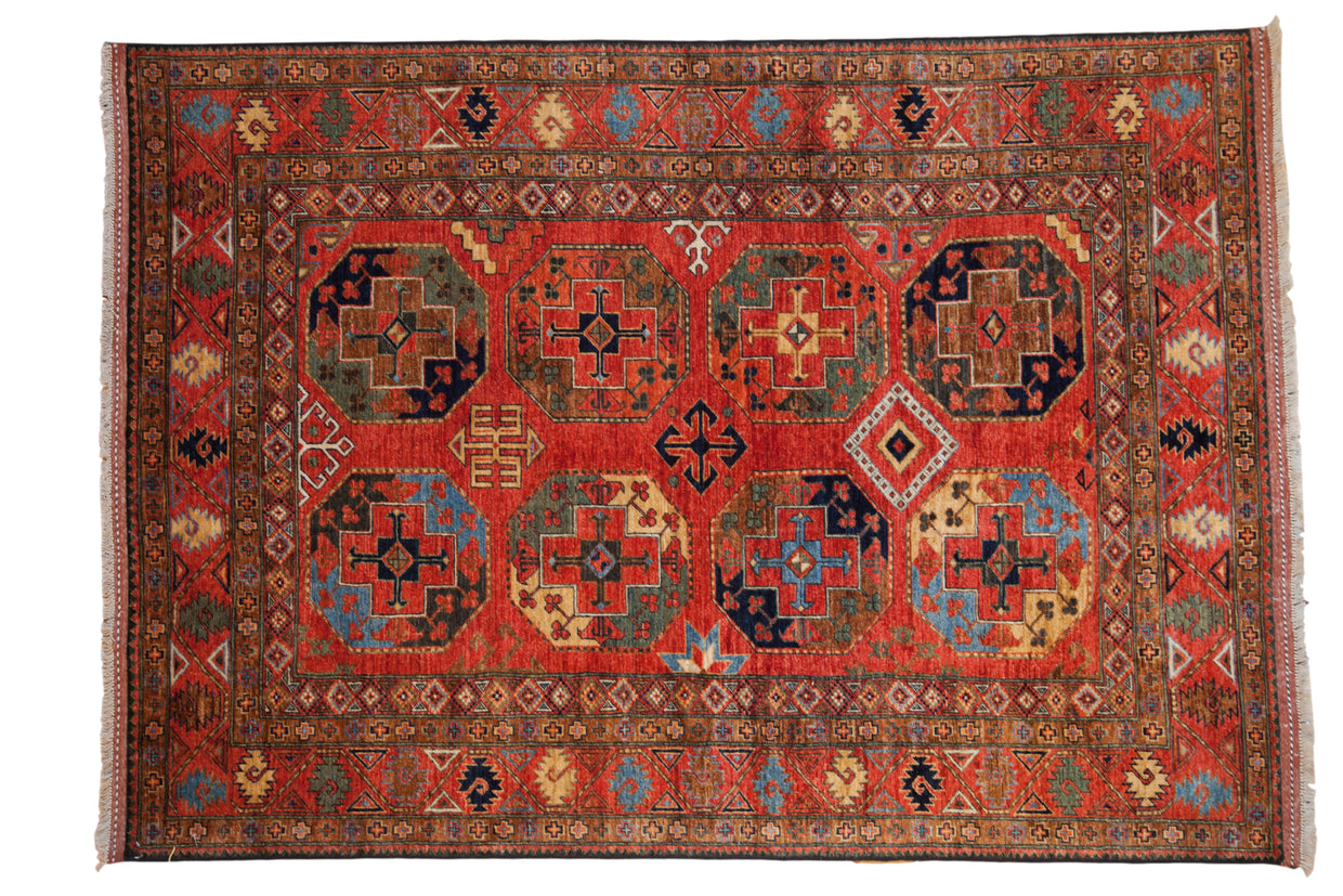 Hand knotted Pakistani Ersari design rug with deep red field and bold gem-toned geometric guls.