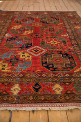 Intricate geometric guls and decorative border in rich cherry red, sapphire, emerald tones.
