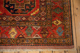 Cherry red Pakistani Ersari design rug corner with geometric patterns and beige fringe.