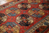 Cherry red and sapphire blue geometric patterns on Ersari design carpet's lustrous wool pile.