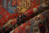 Textured wool pile of a folded Ersari rug, highlighting geometric guls in gem tones.