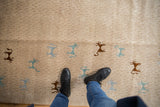 Soft, even pile and pictorial animal motifs of a folk art Indian carpet shown underfoot.