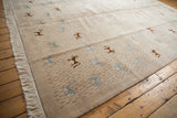 Textured pile, folk art animal figures, and clean fringe on a hand-woven Indian carpet.