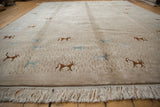 Angled view of an Indian folk art carpet showing the plush beige pile and clean ivory fringe.