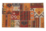 New geometric patchwork Kilim rug with visible cross-stitch seams, warm red and orange.