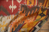 Patchwork Kilim rug, fragmented geometric panels with simulated cross-hatch stitching, brick red and brown tones.