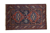 Vintage Indian rug in a Caucasian design with two geometric medallions in rust, powder blue, and navy.