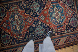 Saturated navy and rust geometric medallions on the lustrous pile of a vintage Indian rug.