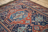 Angled view of the vintage rug's dynamic reciprocating border and rich, lustrous pile.