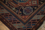 Detailed corner of a vintage Indian rug showing the dynamic, stepped geometric border and high-luster pile.