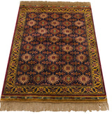 Detailed corner of vintage Indian Caucasian design rug: geometric finned guls, starburst floral vine border.