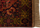 Bakhtiari rug corner: golden border, dusty red and navy floral patterns, intact fringe.