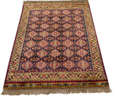The lustrous pile and rich color of a vintage Indian rug with a geometric Caucasian design.