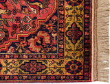 The intricate floral border in navy, red, and gold on a vintage Indian rug with full pile.