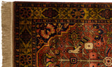 Corner of a vintage Bakhtiari rug with a perched bird, floral vines, and a gold border.