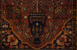 Detail of traditional Bakhtiari design featuring a navy blue vase with dusty red and ivory floral vines.
