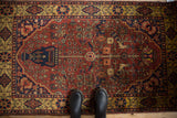Overhead view of a vintage Indian Bakhtiari rug with its tree-of-life pattern in red, blue, and gold.