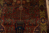 Perched birds and floral blossoms on vines emerging from a navy vase on a vintage Bakhtiari rug.