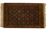 Vintage Indian rug with a repeating geometric pattern of finned floral guls in rich red, gold, and navy.