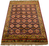 Angled perspective of a vintage Indian rug highlighting the sheen on its allover geometric design.