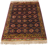 Richly saturated geometric patterns on the lustrous navy pile of a vintage Indian rug.
