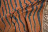 Fringed edge, flatweave texture, and rust orange with charcoal tiger stripes on this vintage Indian Kilim.