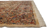 A vintage Kerman carpet's plush, full pile and intact ivory fringe shown from a low angle.