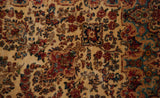 Detailed millefleur floral bouquets on the lush, hand-knotted pile of a vintage Kerman carpet.