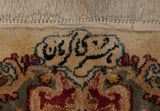 Weaver's signature in navy blue script on the full ivory pile of a vintage Kerman carpet.