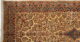 Vintage Kerman carpet corner with an ornate Rococo-style border and dense millefleur pattern.