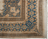 Kerman carpet corner showcasing ivory, sky blue, gold Rococo stylization and patterned borders with fringe.
