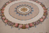 Curvilinear pink rose garland and powder blue motifs on a vintage Spanish Savonnerie rug.