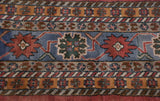 Geometric border bands on vintage Indian rug in slate blue, brick red, saffron, and mallard green.