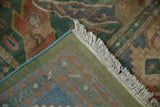 Corner view of Indian Caucasian carpet showing its woven green back, blue side cord, and tinted fringe.