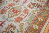 Indian Caucasian design carpet's floral palmettes in rust, gold, seafoam, and ivory geometric border.