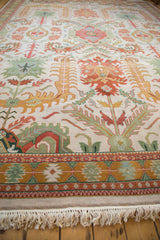 Ivory fringe and a multi-layered geometric border in gold, rust, and seafoam green.