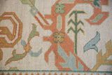 Hand-knotted texture with rust, seafoam, and gold floral and laurel leaf motifs.