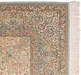 Weaver's signature within the mint green and ivory floral border of a vintage Kerman design rug.