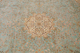 Detailed view of the mille fleur pattern with blush and saffron florals on the mint green carpet pile.