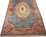 Vintage Kerman carpet with sky blue field, ivory medallion, and European-influenced red rose bouquets.