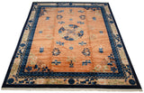 An angled view across a vintage Peking carpet with a lustrous copper field and bold blue border.