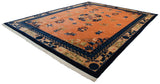 Angled corner view of an oversize Peking carpet with a pale copper field and indigo borders.