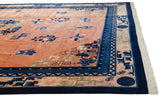 An angle across the pale copper field highlights the intricate, layered indigo borders of the Peking carpet.