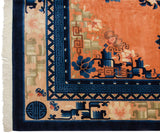 A detailed corner view of a vintage Peking carpet's indigo blue and running-t motif borders.