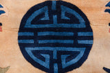 A geometric roundel in indigo and cobalt blue on the full pile of a vintage Peking carpet.