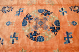 Plush copper pile of a vintage Peking carpet, detailing the roundel medallion in indigo and cobalt blue.