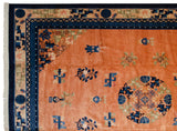Corner of a Chinese Peking carpet with detailed indigo borders and a plush pale copper wool pile.