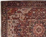 Oversized serrated leaf spandrel and intricate indigo border on a vintage Persian Heriz carpet.