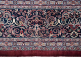 Detail of a vintage Kashan design carpet's powder blue floral border and solid burgundy end.