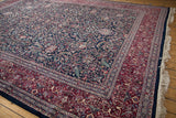 Kashan design rug corner: navy floral arabesque field, rich burgundy border.